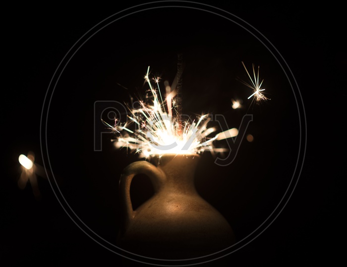 burning sparkler light In a Vase Over an Isolated Black Background