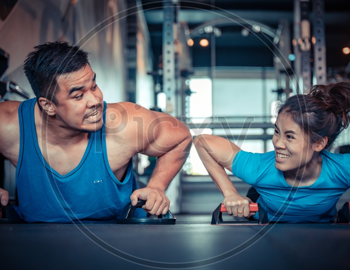 Couple exercising in the gym with dumbells
