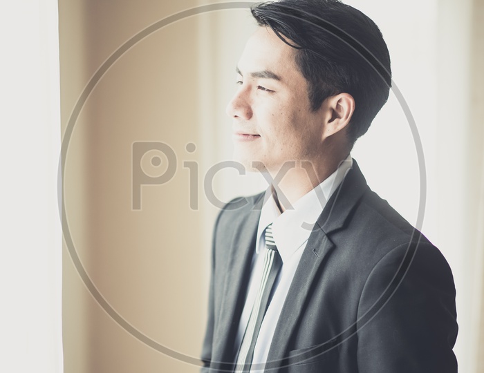 Young Businessman Enjoying Coffee and Sunshine From a Office room Window