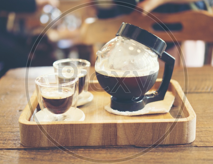 coffee pot and cups on a wooden tray, vintage filter image - Nitro cold brew coffee