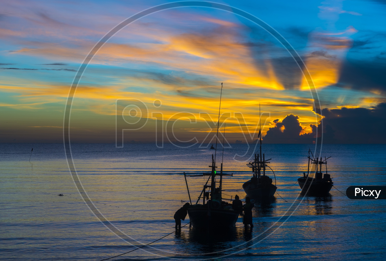 Fishing Boats In a Beach With  Fisherman Carrying Their Catch Over a Blue hour  Sunset Sky In Background