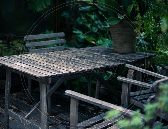 Old wooden dining set for outdoor furniture in tropical garden, cafe table