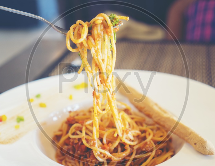 Spaghetti al sugo pomodoro basilico picked with a fork
