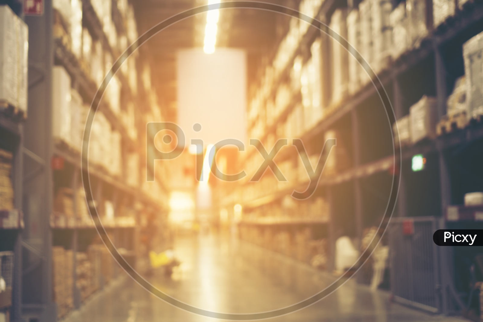 Blurred image of shelf in modern distribution warehouse or storehouse. Defocused background of industrial warehouse interior aisle