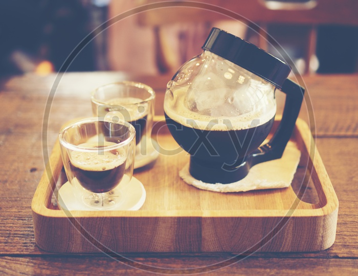 coffee pot and cups on a wooden tray, vintage filter image