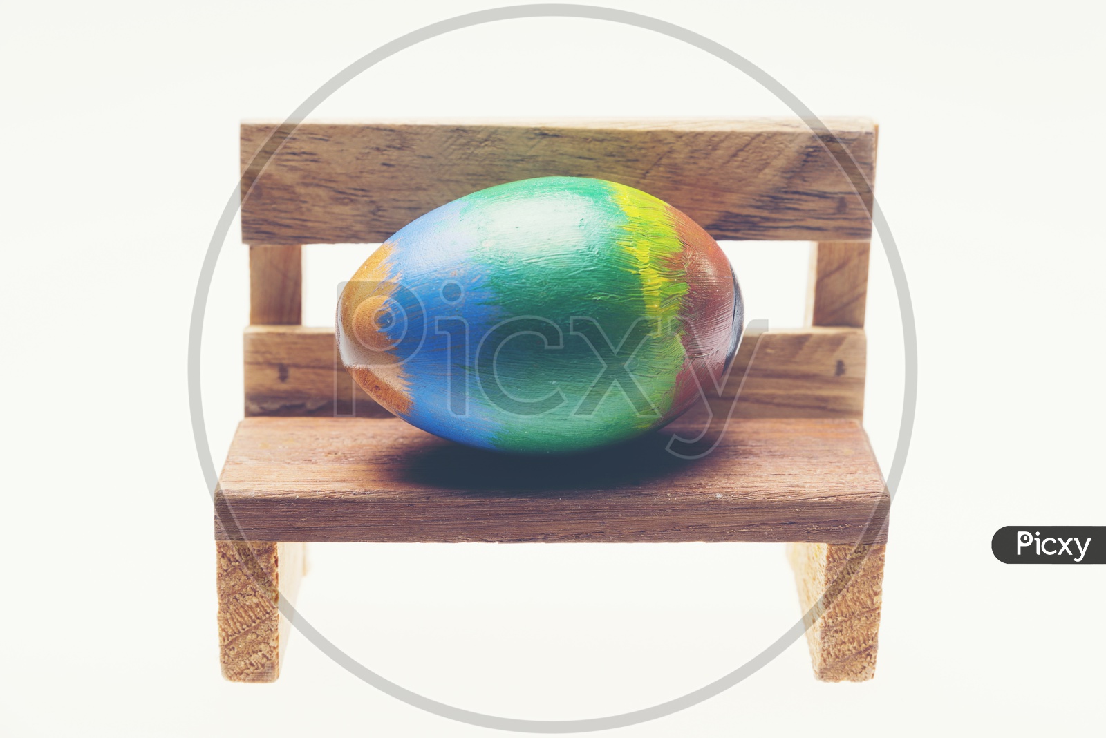 Colorful Handmade Easter Egg On Wooden Bench on an Isolated white Background