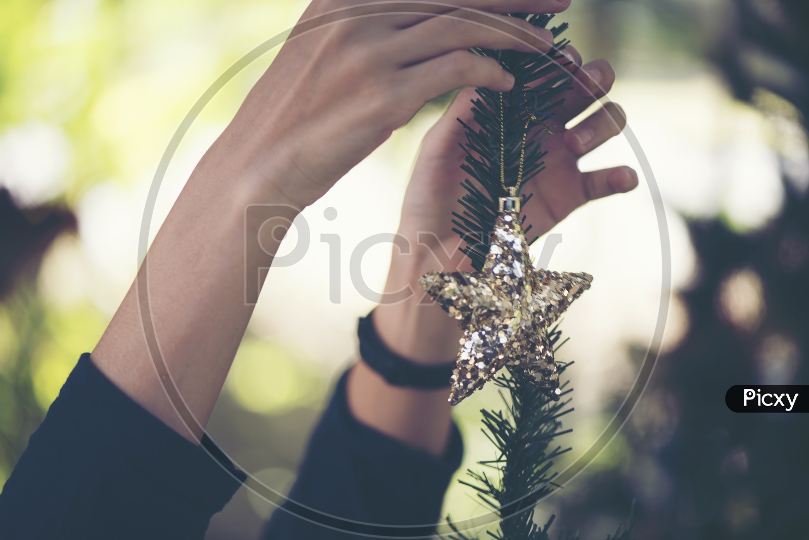 Woman Hands Decorating Christmas tree With Bells And Gifts For Christmas Festival