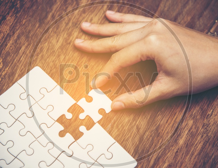 Startup  Business Entrepreneurs  hand connecting jigsaw puzzle.