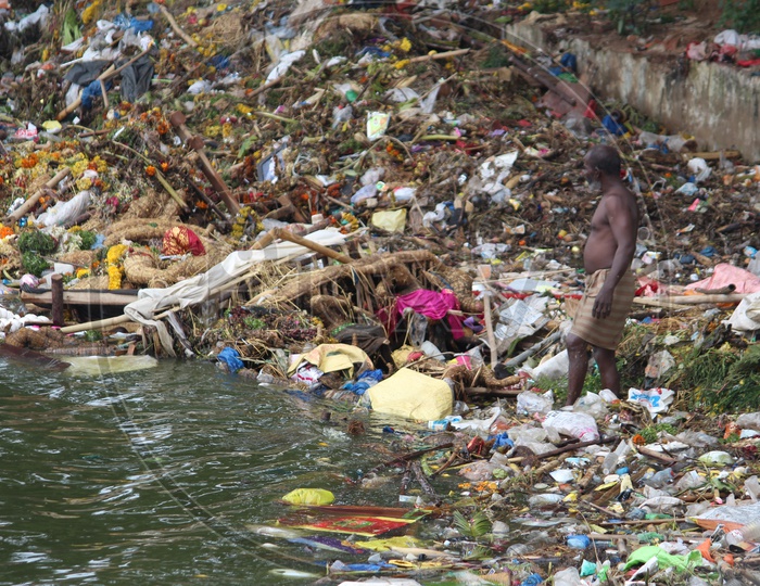 Man collecting the plastic in the tank bund on the day of Ganesh nimajjanam.