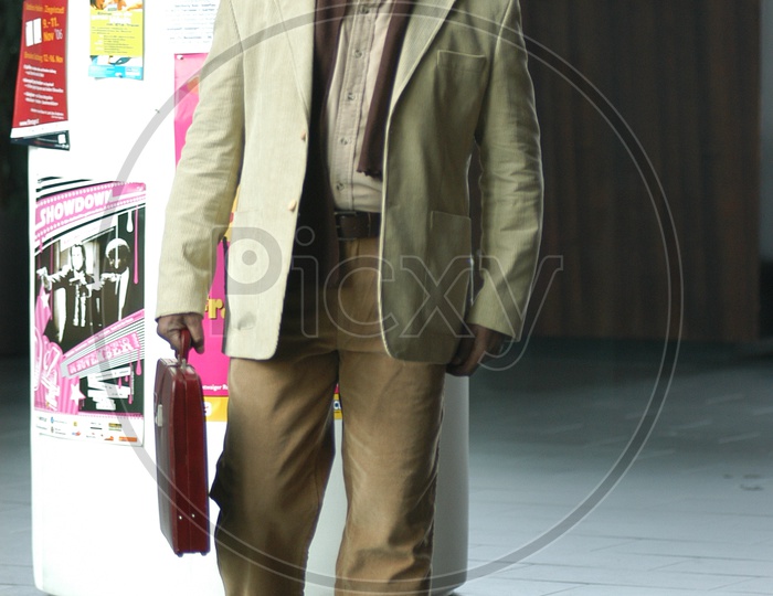 Indian man carrying a briefcase wearing a suit