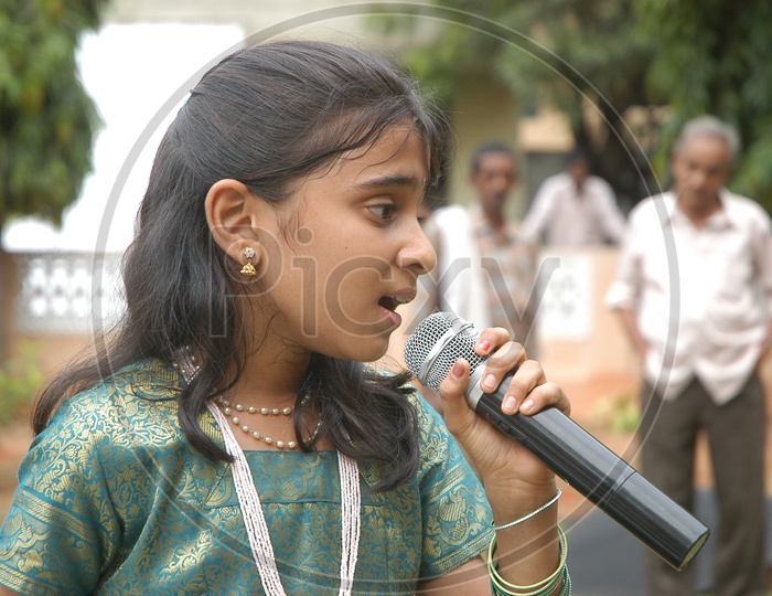 Indian little girl singing on the mic