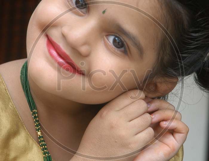 Indian little girl adjusting her earrings