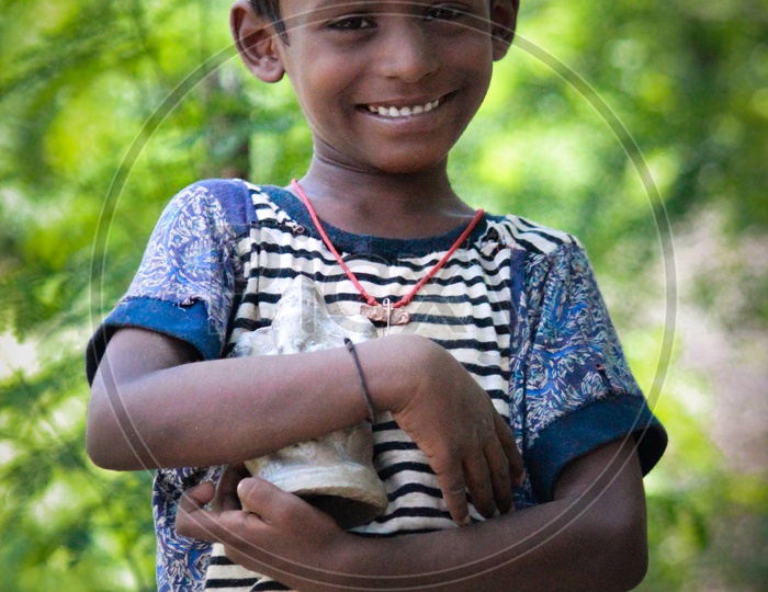 A little boy holding the eco friendly ganesh idol done by him.