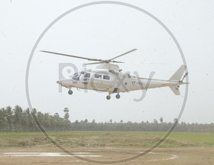 A Helicopter Landing on Helipad with Agriculture Fields in Background