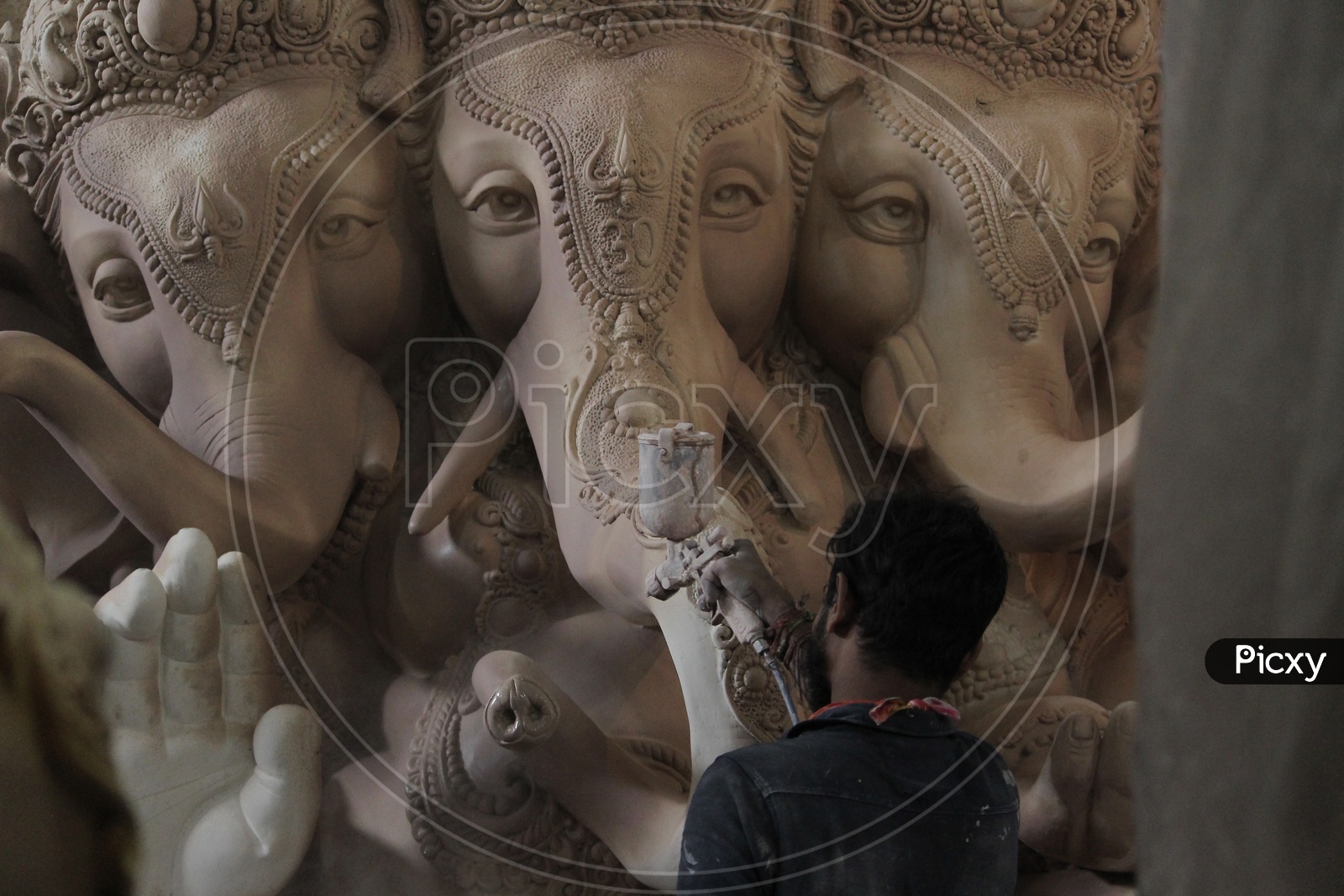 Man painting the lord ganesh statue.