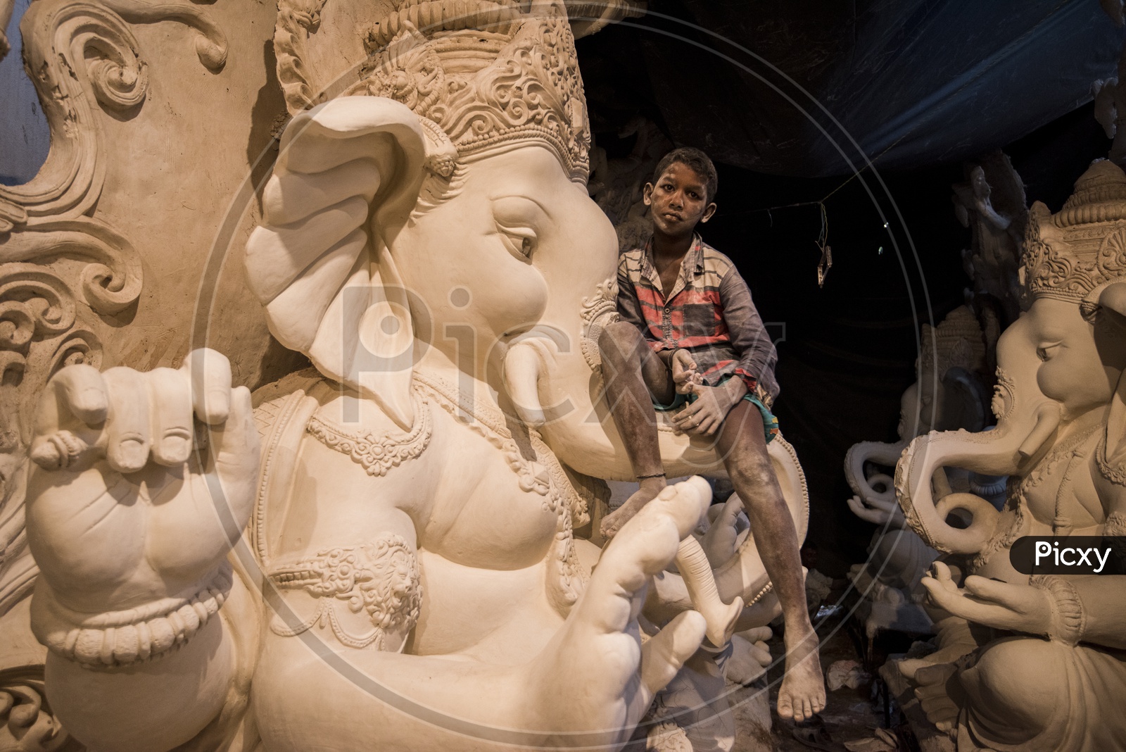 sculptures of ganesha with child sitting on it