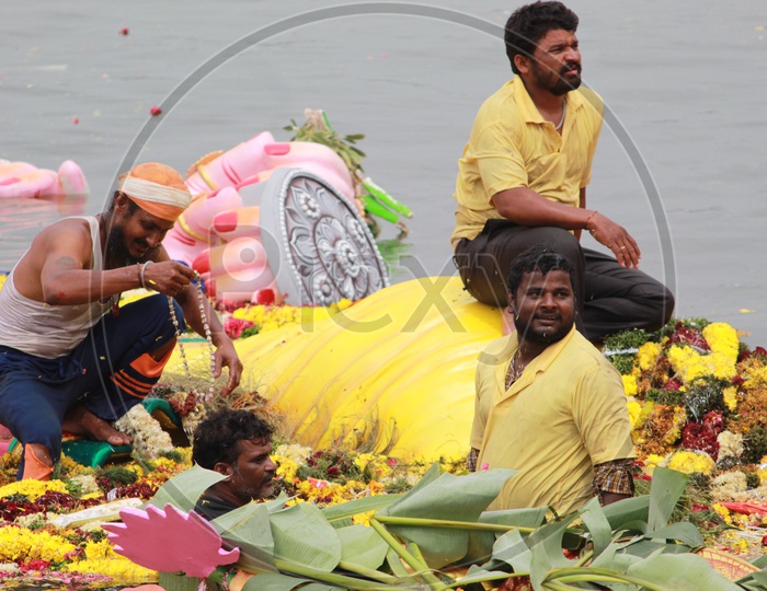 Men Picking the Offerings From Ganesh Idol