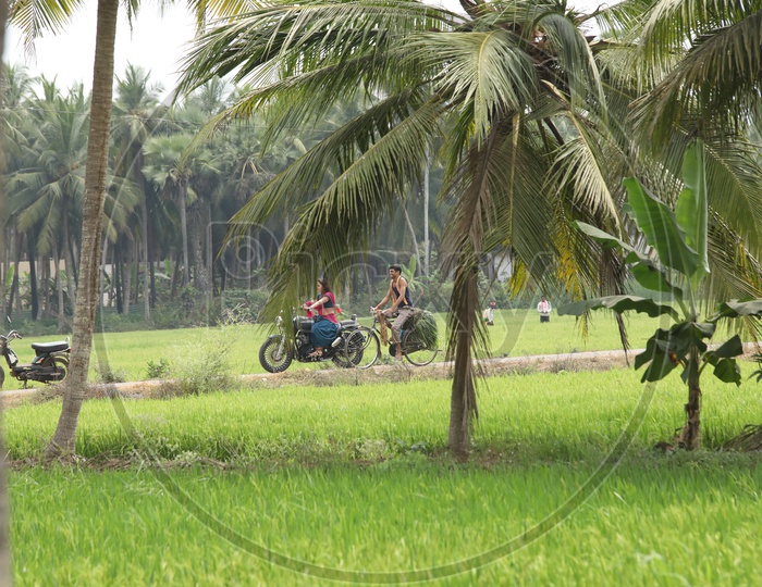 Indian Woman riding a Thunderbird bike through the fields