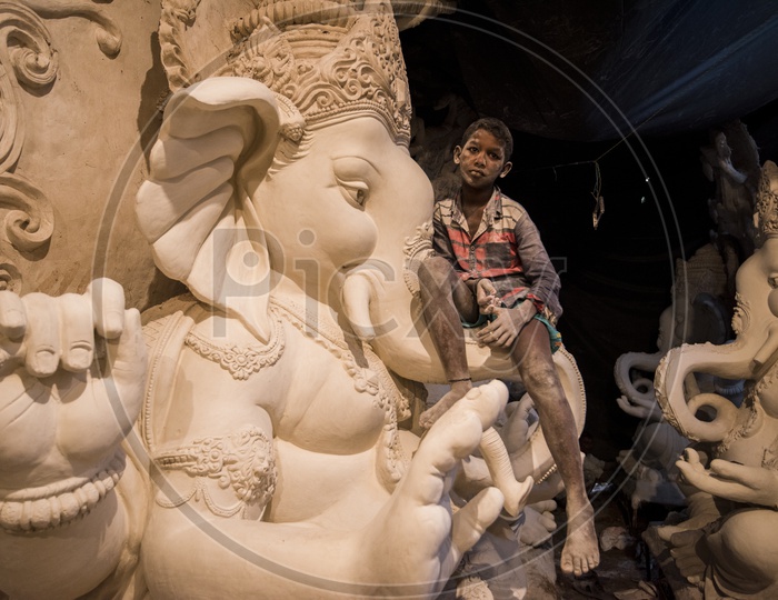 sculptures of ganesha with child sitting on it