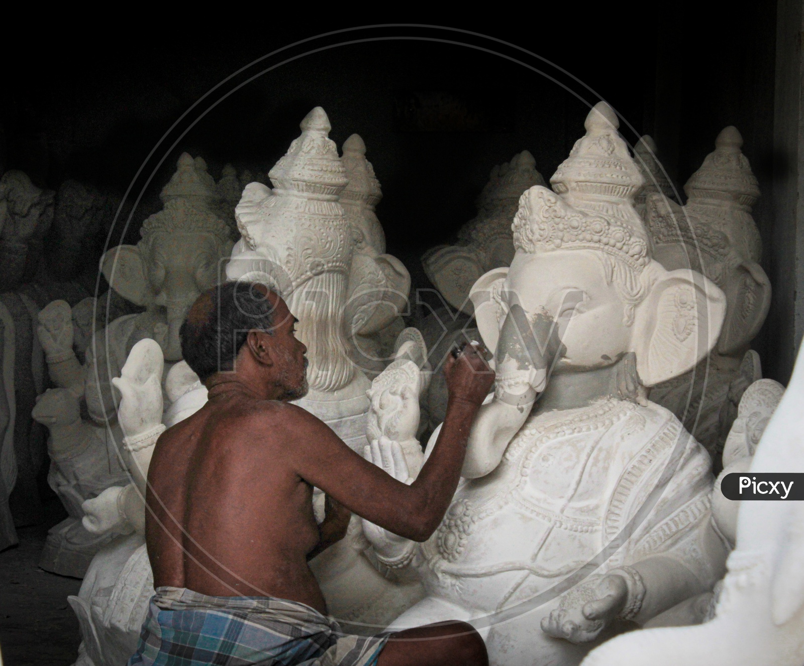 A man fixing different parts of  ganesh idol accordingly.