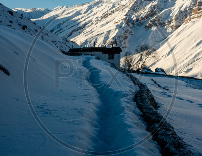 Trekking Path in Snow with Snowy Mountains in Background