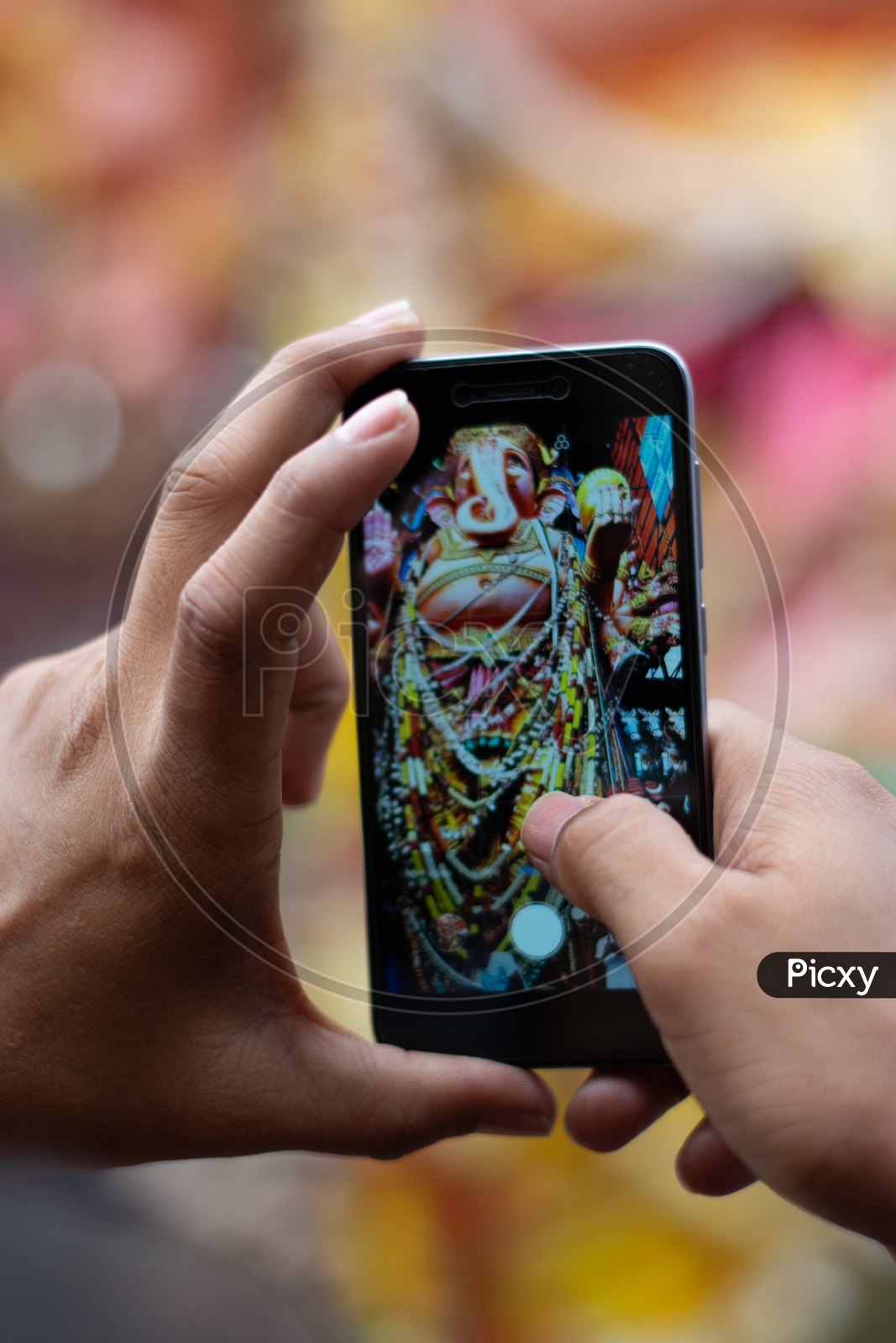 A Devotee taking Picture of Khairatabad Ganesh Idol on Mobile or Smartphone