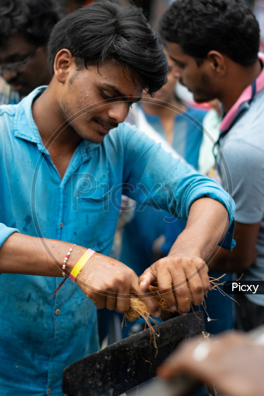Indian Male Devotee breaking Coconut in Temple