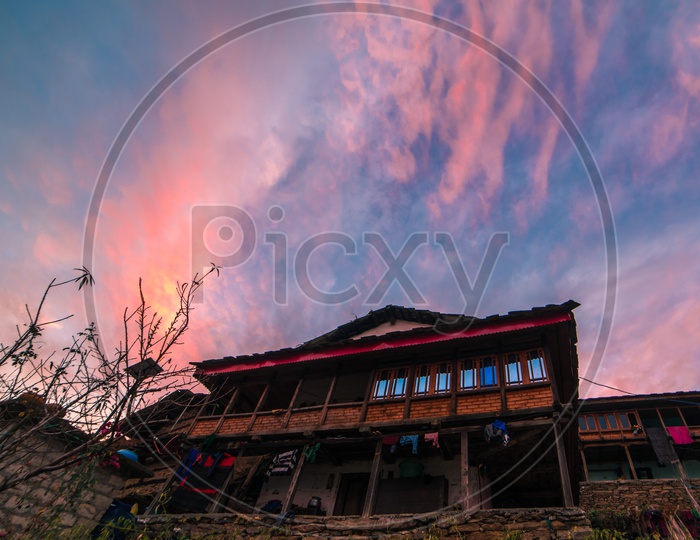 Sunset over a traditional wooden house in Rural Village in the Himalayas