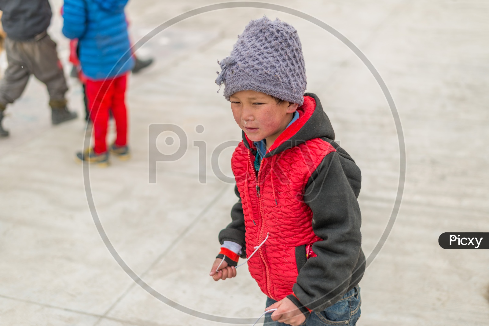 A Kid with Red Jerkin or Jacket in Winter at Monastery playing