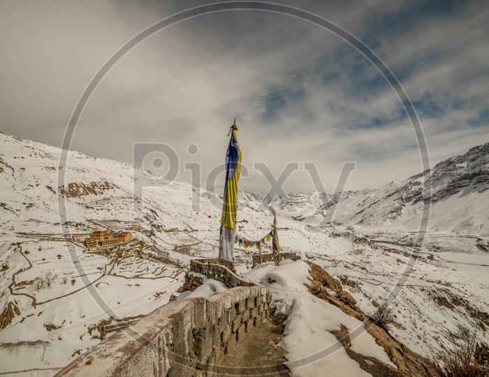 Prayer Flags on Walls with Snow Capped Beautiful Himalayan Mountains in Winters