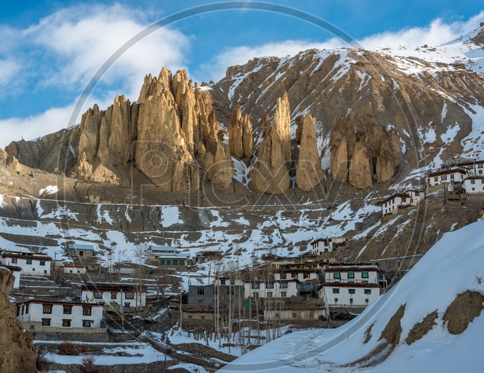 A Village on Mountain Covered in Snow with Rock Mountains in Background