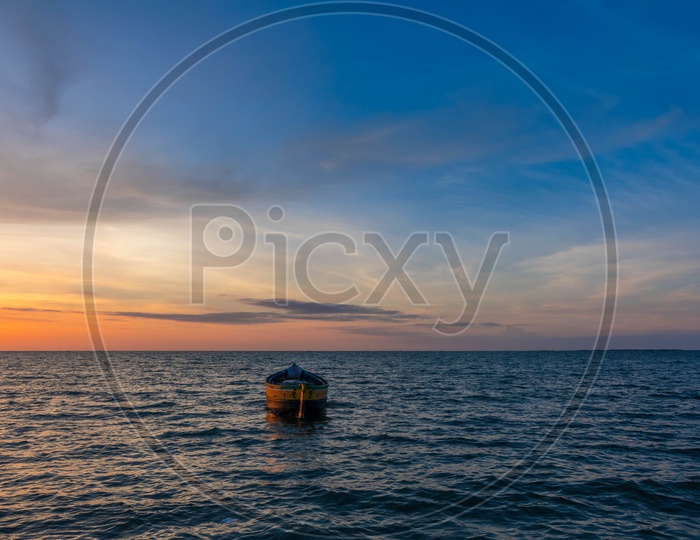 A boat in the middle of the sea during sunset