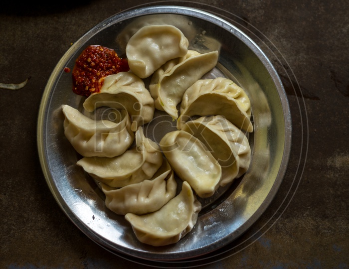 Nepalese traditional dumpling steamed momos served with schezwan sauce