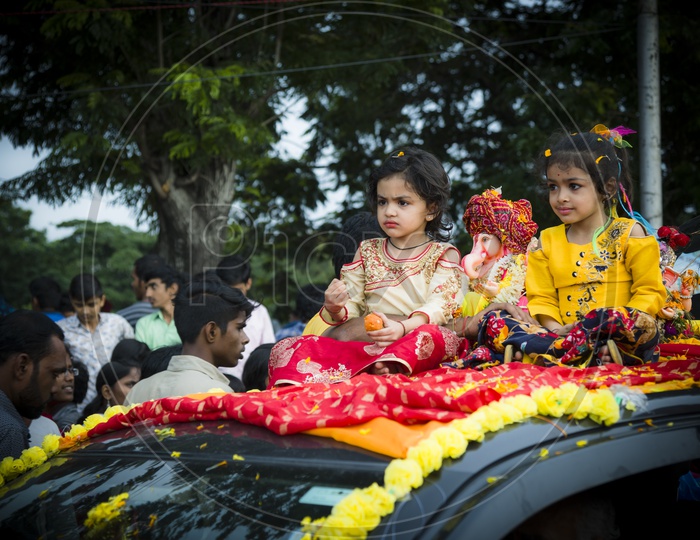 Cute little Angels with cute Ganesh on Car rooftop