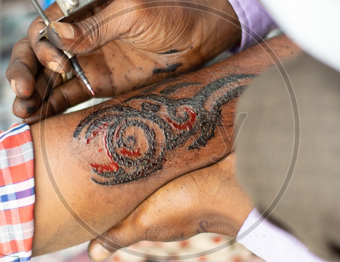 Roadside Artist doing Tattoos on a Indian Man