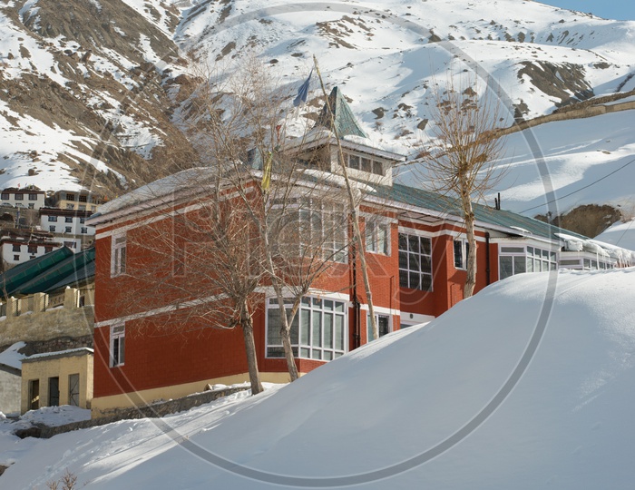 Beautiful Houses in Snow with Snowy Himalayan Mountains in Background