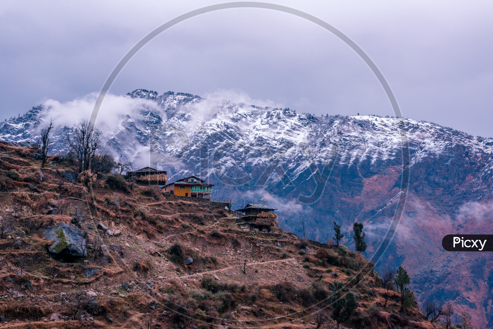 Houses on Mountain Top with Snow Capped Himalayan Mountains in Background