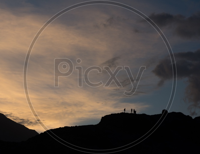 Silhouette of travellers on top of the mountain