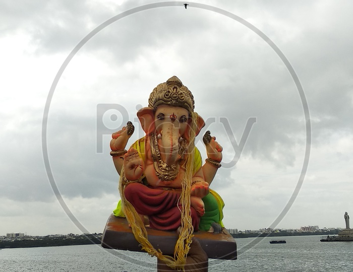 Man Holding Ganesh Idol in Hand At Tank Bund During Immersion or Visarjan