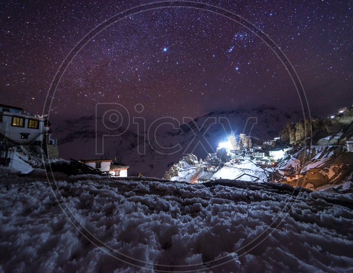 Night View of a Village Covered in Snow with Stars in Sky