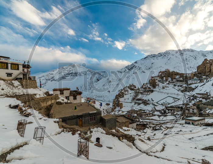 Spiti Village on Mountains Covered in Snow with Clouds in Sky Background