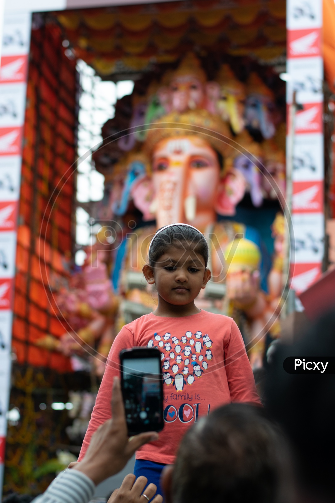 Mother Taking Picture of her Kid with Khairatabad Ganesh Idol in Background