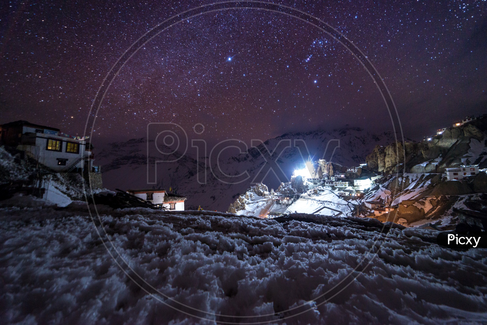 Night View of a Village Covered in Snow with Stars in Sky