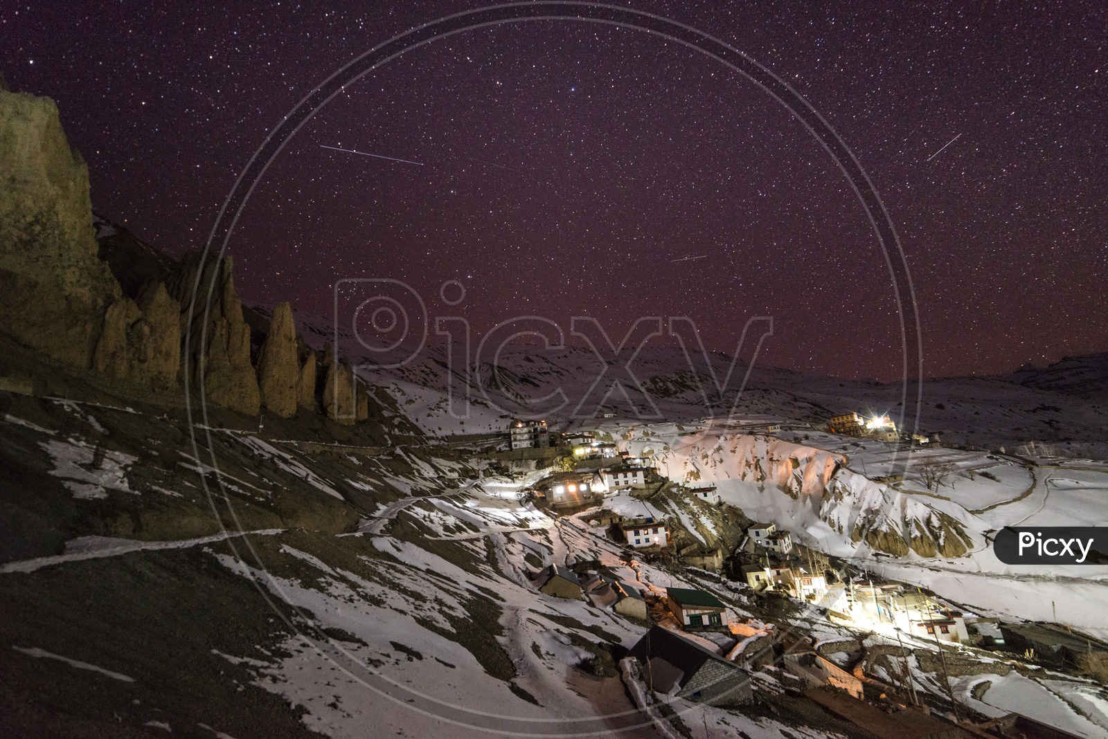 Night View of Spiti Village Covered in Snow with Stars in Sky