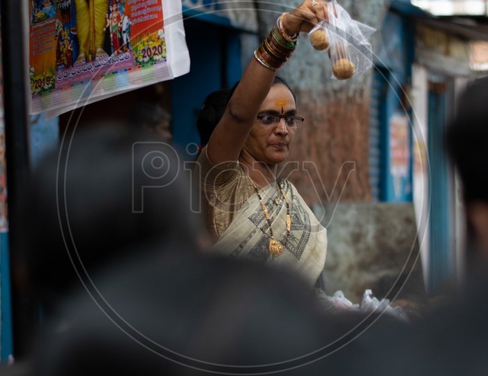 Woman selling Laddus or Ladoo Sweet at Khairatabad Ganesh Temple