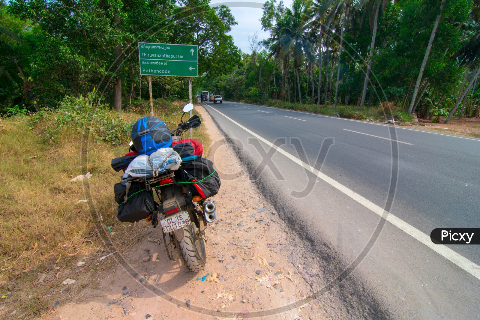 A Traveler's bike parked alongside the road at Tiruvananthapuram highway 
