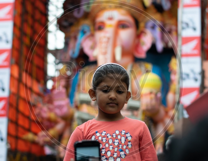 Mother Taking Picture of her Kid with Khairatabad Ganesh Idol in Background