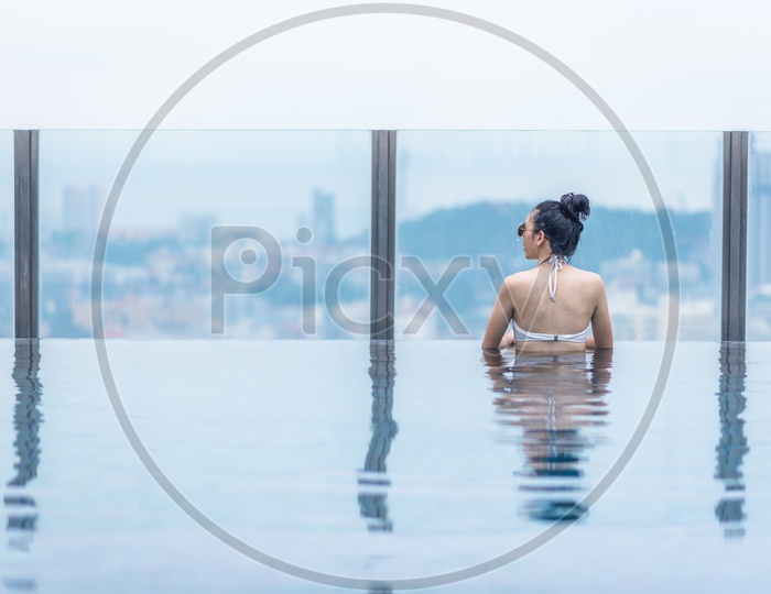 An Asian Swimming pool on roof top with beautiful city and sea view
