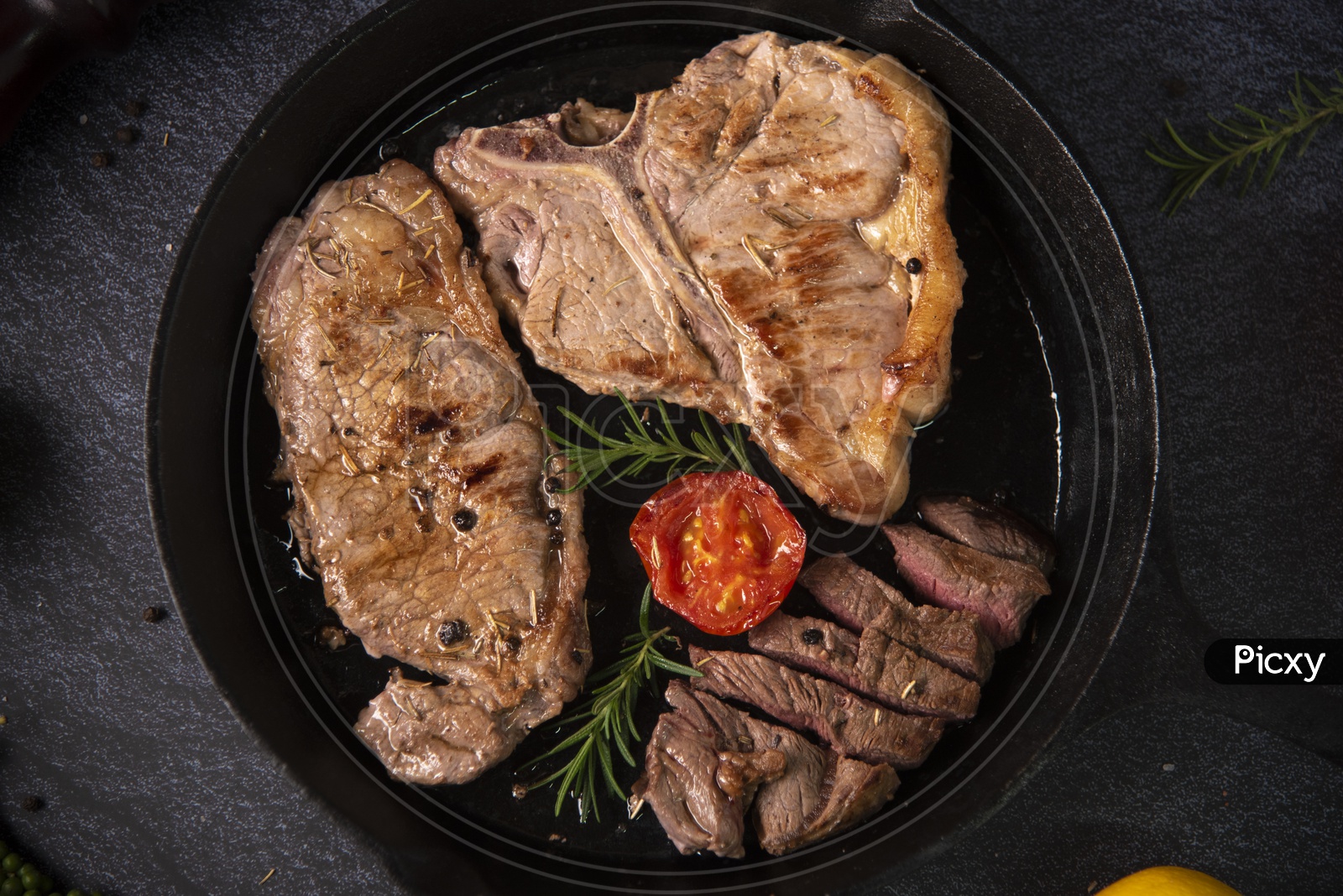 grilled beef steaks with spices on black pan