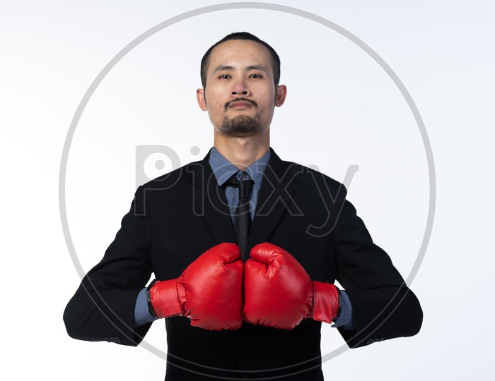 Business Man Wearing Boxing Gloves And Posing As a Symbol Of Giving Tough fight To His Competitors